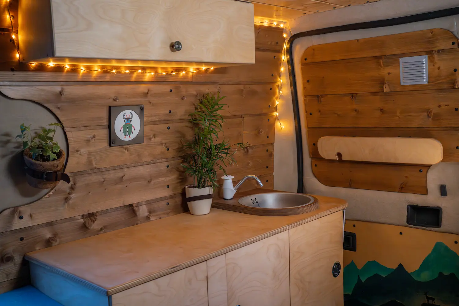 van aménagé évier pompe mécanique plante ceinture en cuir