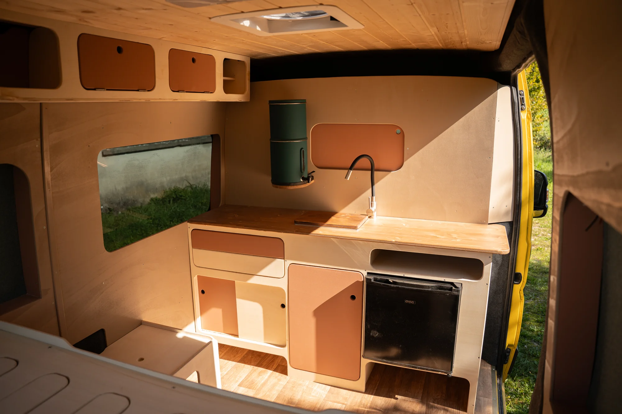 Intérieur d'un van aménagé avec cuisine et rangements